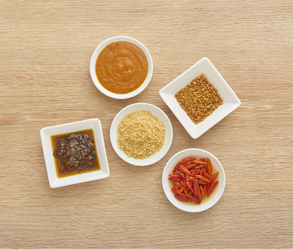 An assortment of condiments on small white dishes.