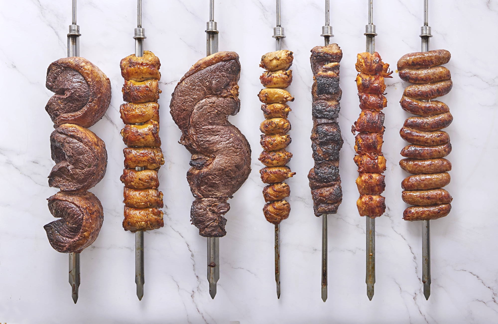 different meats on silver skewers